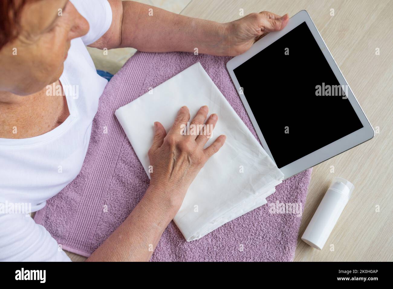 beffa, una donna anziana guarda un tablet, alla ricerca di informazioni, copia incolla Foto Stock