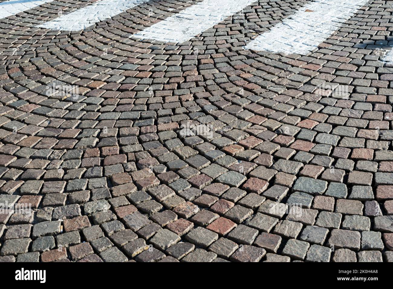 Marciapiede della città di Milano con strisce bianche di attraversamento pedonale Foto Stock