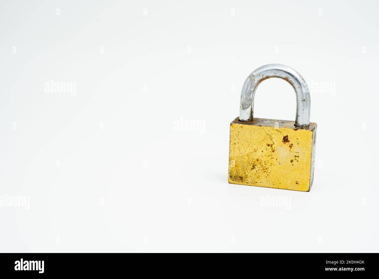 un vecchio lucchetto chiuso (bloccato) color oro posto in posizione verticale Foto Stock