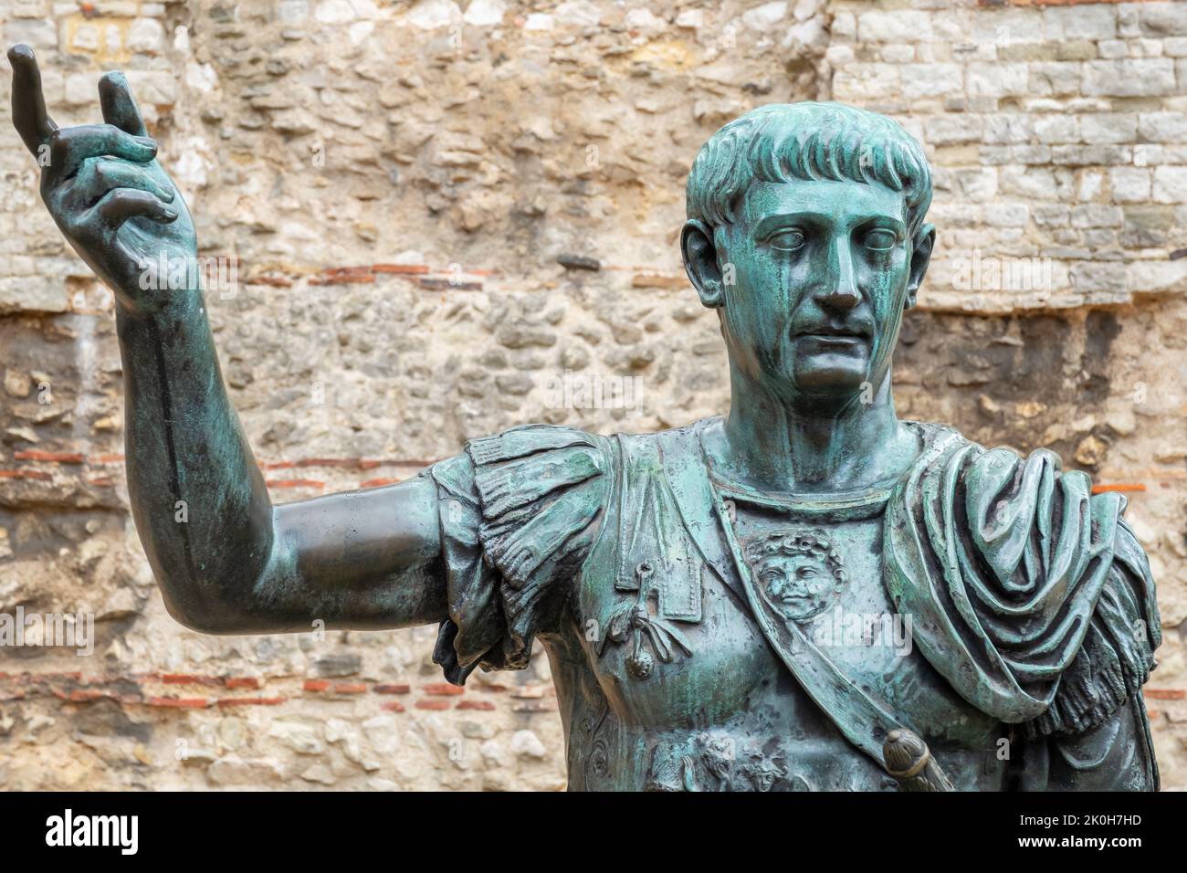 Statua in bronzo dell'imperatore romano Traiano prima dei resti del Muro di Londra. Londra, Inghilterra Foto Stock