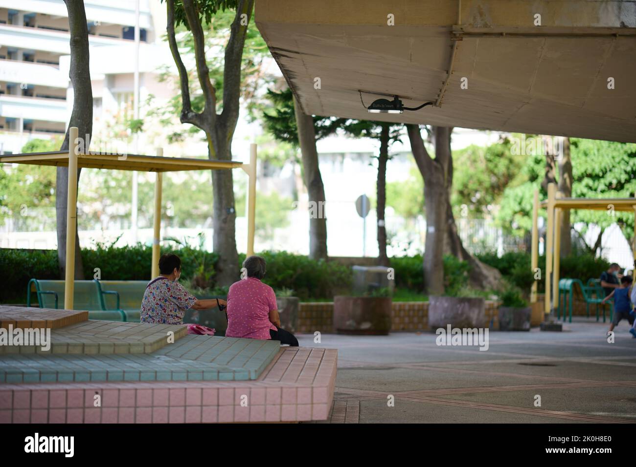 Due donne anziane sedute in un parco a Wah fu Estate a Pok fu Lam, Hong Kong, in una giornata di sole Foto Stock