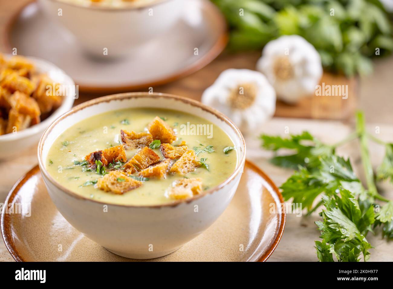 Zuppa all'aglio con crostini di pane e condita con foglie di sedano in coppe. Foto Stock