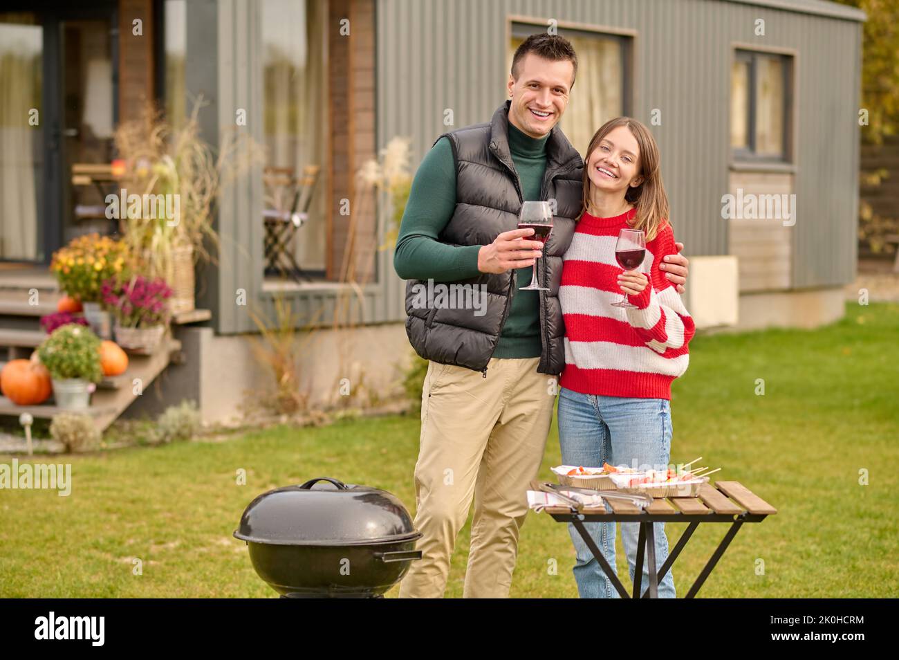 L'uomo allegro e la sua compagna che si divertono con il barbecue Foto Stock L'uomo allegro e la sua compagna che si divertono con il barbecue Foto Stock
