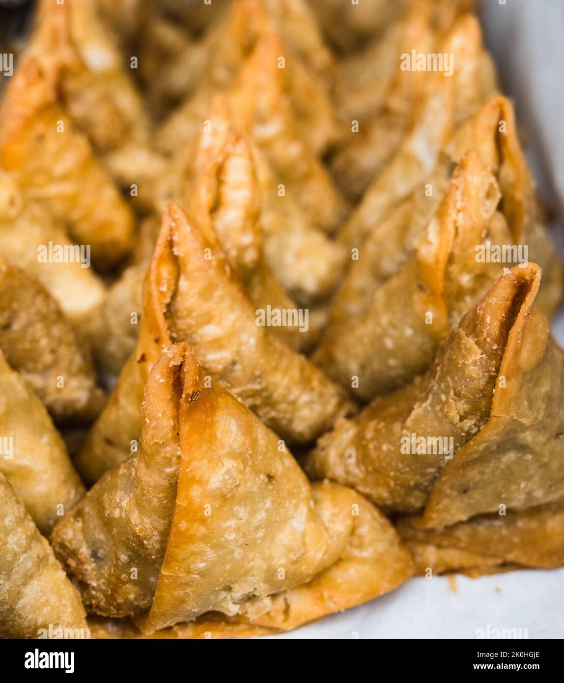 Un primo piano di samosa a forma triangolare Foto Stock