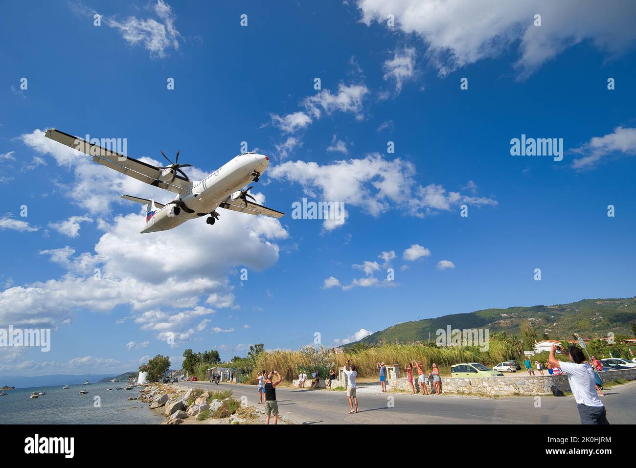 Persone che scattano foto di un aereo a bassa quota in Grecia Foto Stock