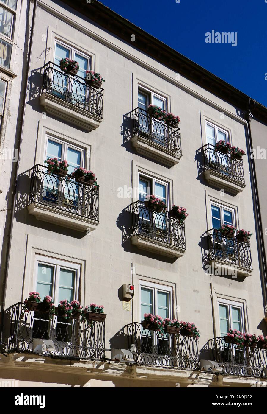 Facciata di un edificio con scatole di fiori sui balconi in un pomeriggio di sole Burgos Castiglia e Leon Spagna Foto Stock