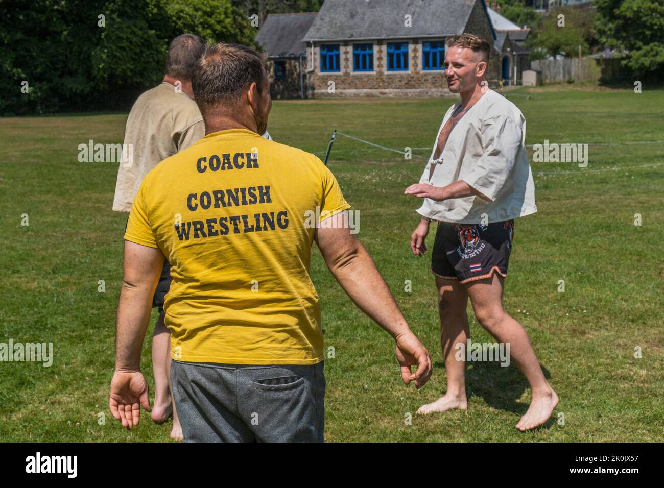 Un pullman che spiega le regole e le tecniche di Cornish Wrestling prima dell'inizio del torneo di Grand Cornish Wrestling nel pittoresco villaggio Foto Stock