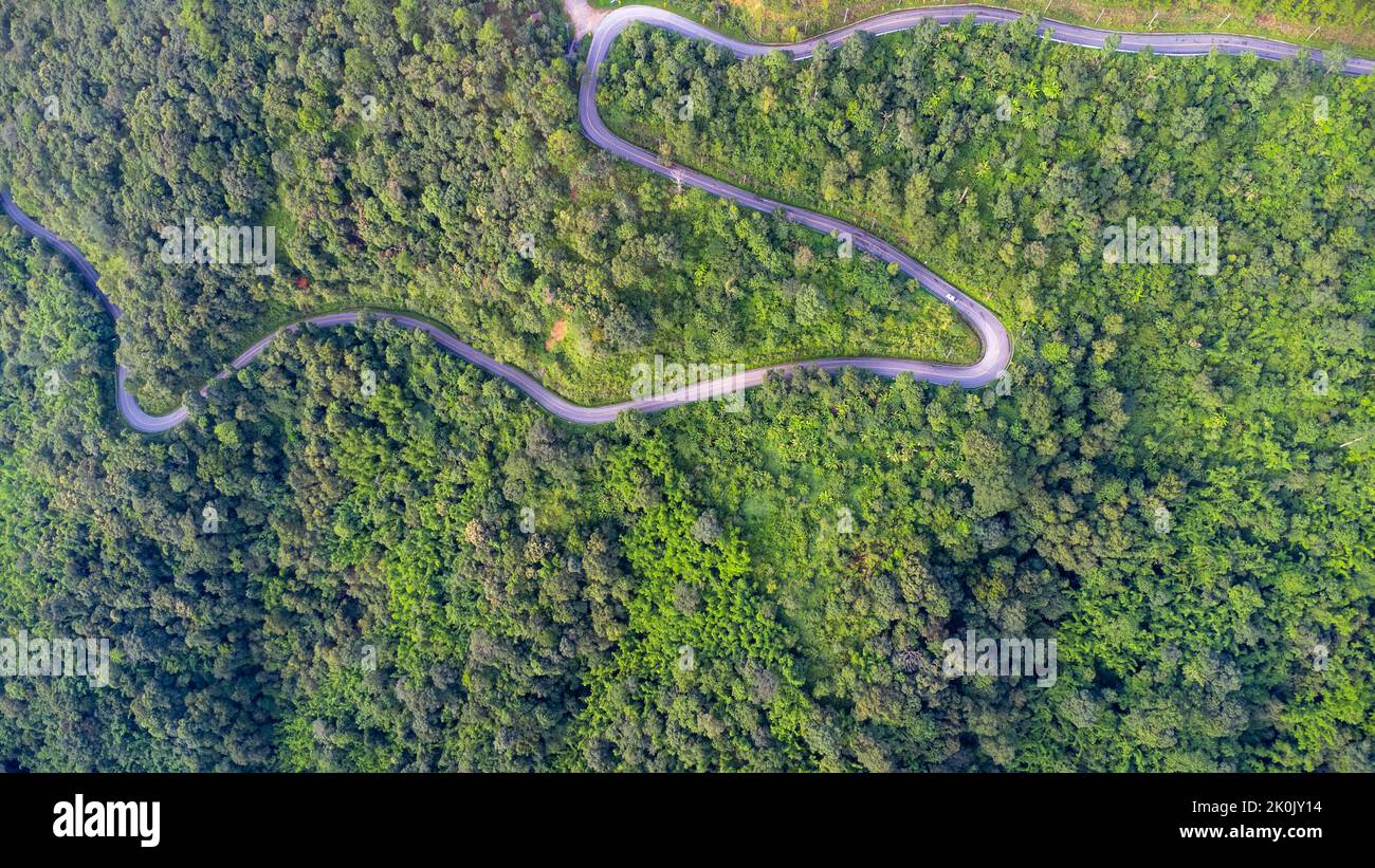 Veduta aerea di una strada collinare con belle foreste verdi in Thailandia. Acquisizione aerea con drone. Foto Stock