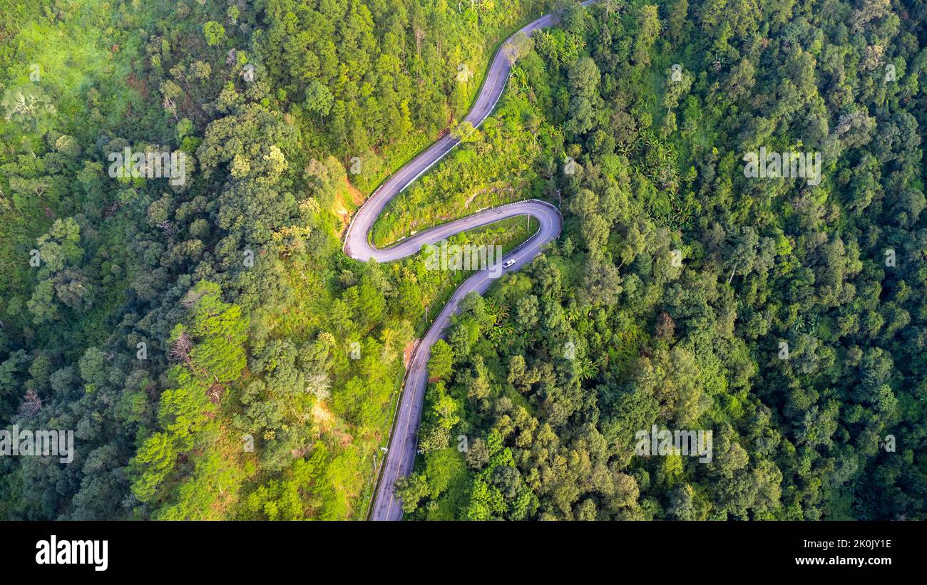 Veduta aerea di una strada collinare con belle foreste verdi in Thailandia. Acquisizione aerea con drone. Foto Stock