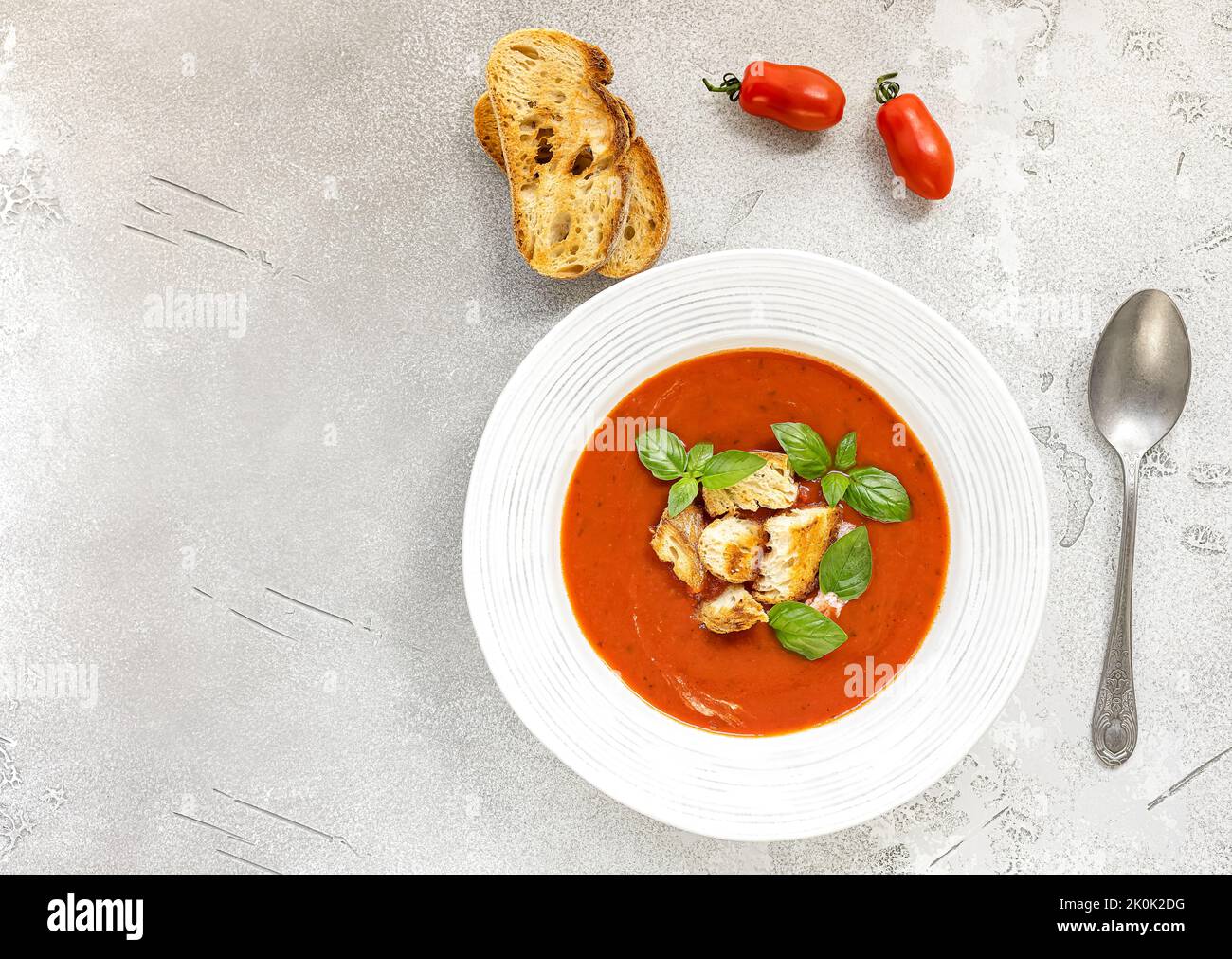 Zuppa di gazpacho con pane, panna e basilico Foto Stock