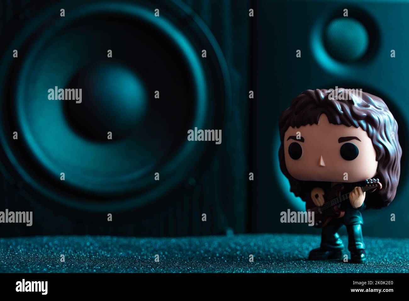 Figura in vinile Funko POPO di John Deacon (Regina) sullo sfondo dei diffusori Foto Stock