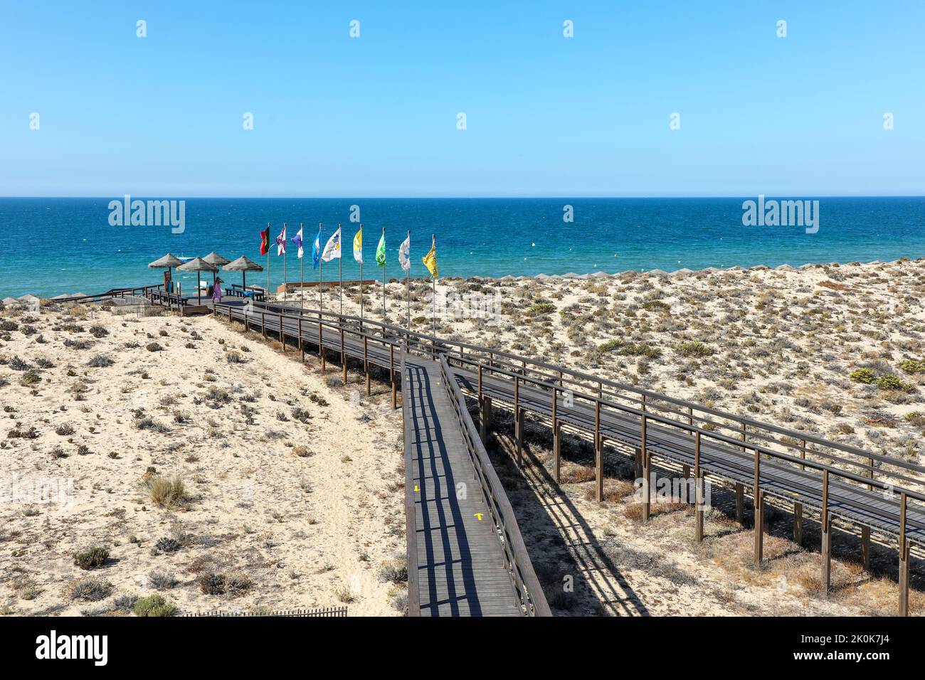 I turisti camminano sulla passerella in legno verso la spiaggia e attraverso la riserva naturale protetta di Parque Natural da Ria Formosa, vicino a Quinta do Lago Foto Stock