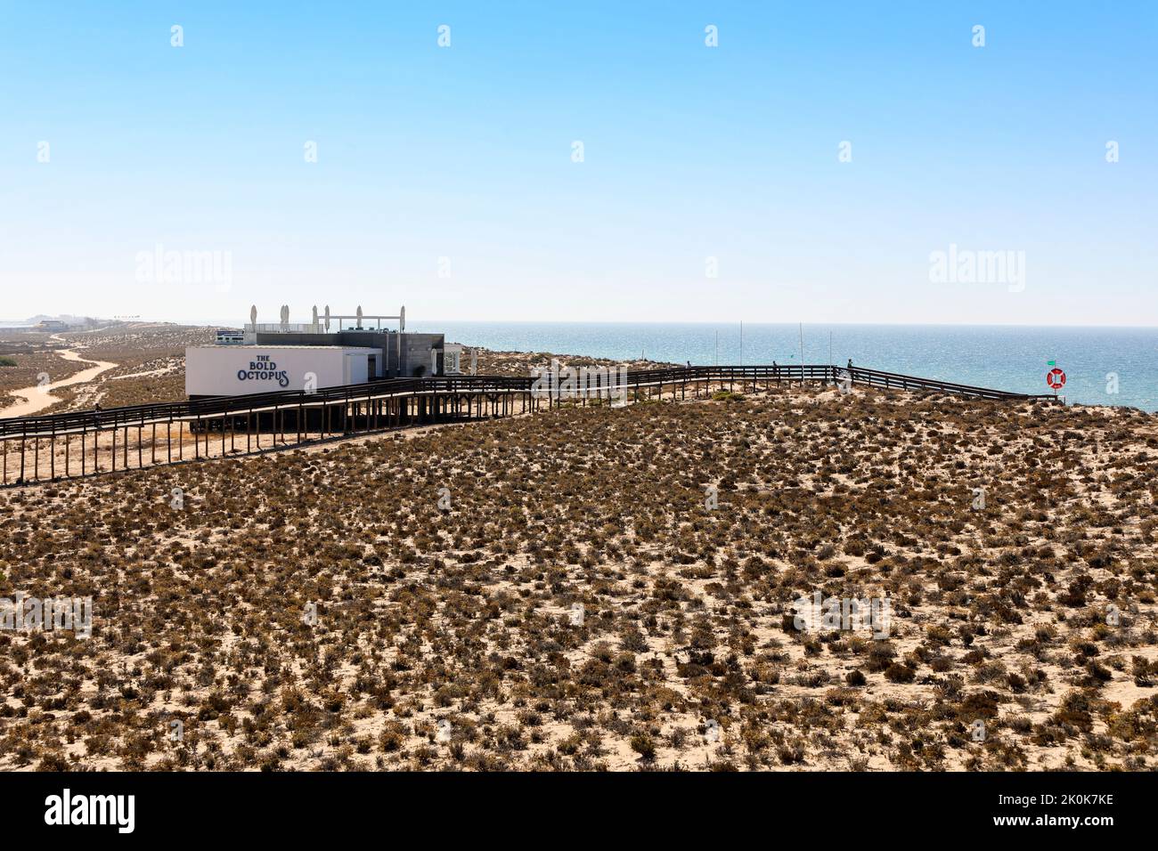 I turisti camminano sulla passerella in legno verso la spiaggia e attraverso la riserva naturale protetta di Parque Natural da Ria Formosa, vicino a Quinta do Lago Foto Stock