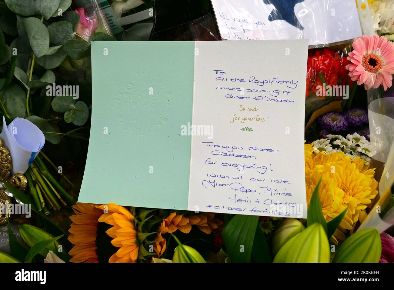 Bouquet, tributi scritti, giocattoli coccolati, candele e carte sono stati deposti in onore della tarda Regina Elisabetta a Green Park e migliaia di persone hanno continuato a affollarsi alla residenza reale Buckingham Palace nel centro di Londra. Foto Stock