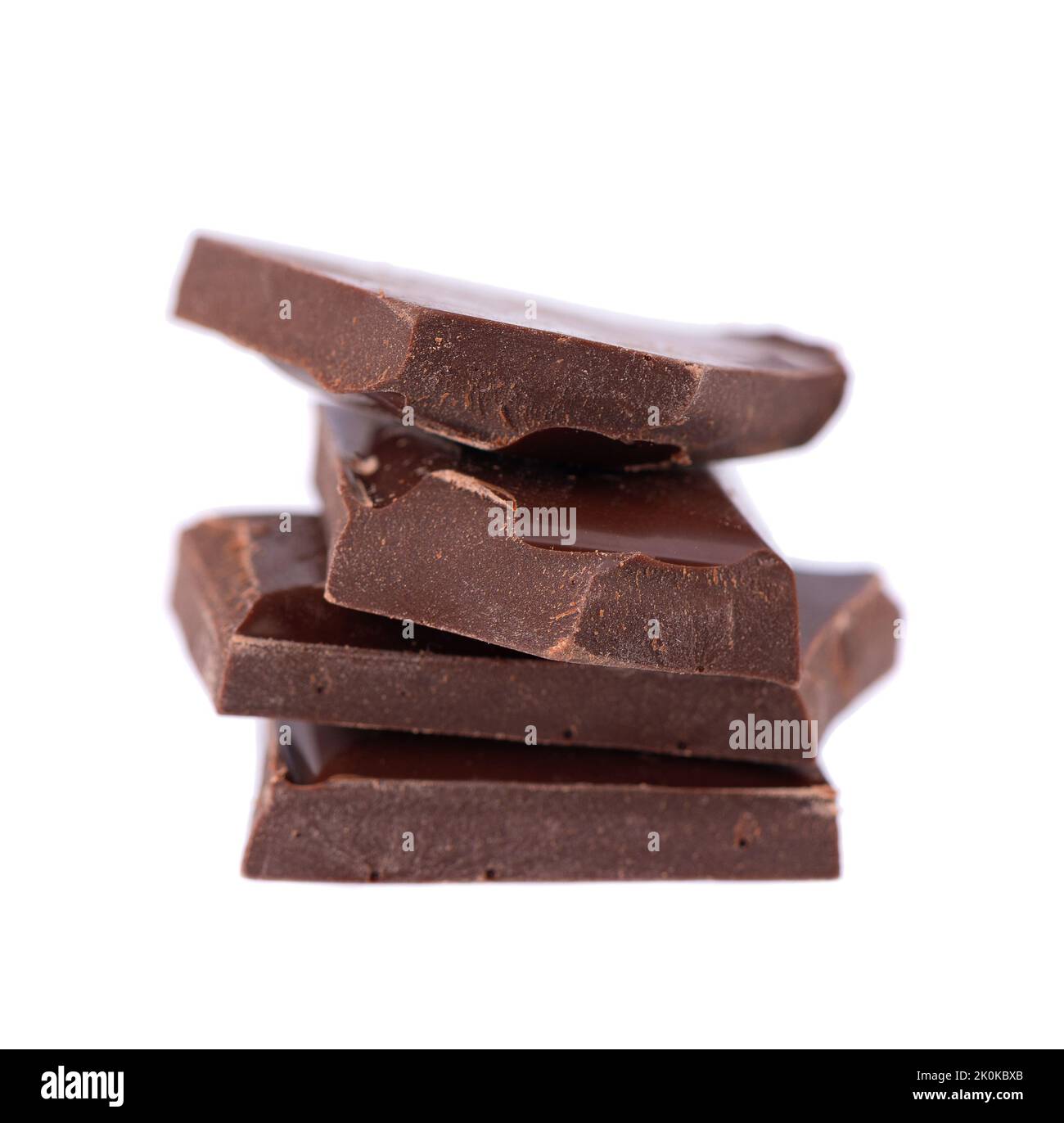 Pile di pezzi di cioccolato isolate su sfondo bianco. Cioccolato fondente. Primo piano Foto Stock