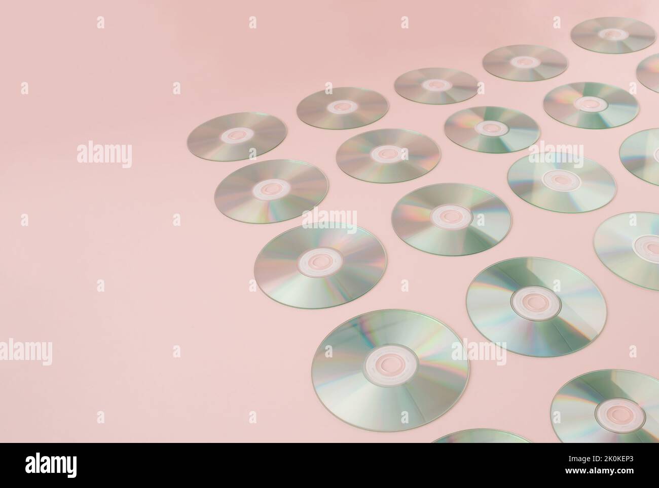 Sfondo retrò con compact disc audio digitali su sfondo rosa. Foto Stock
