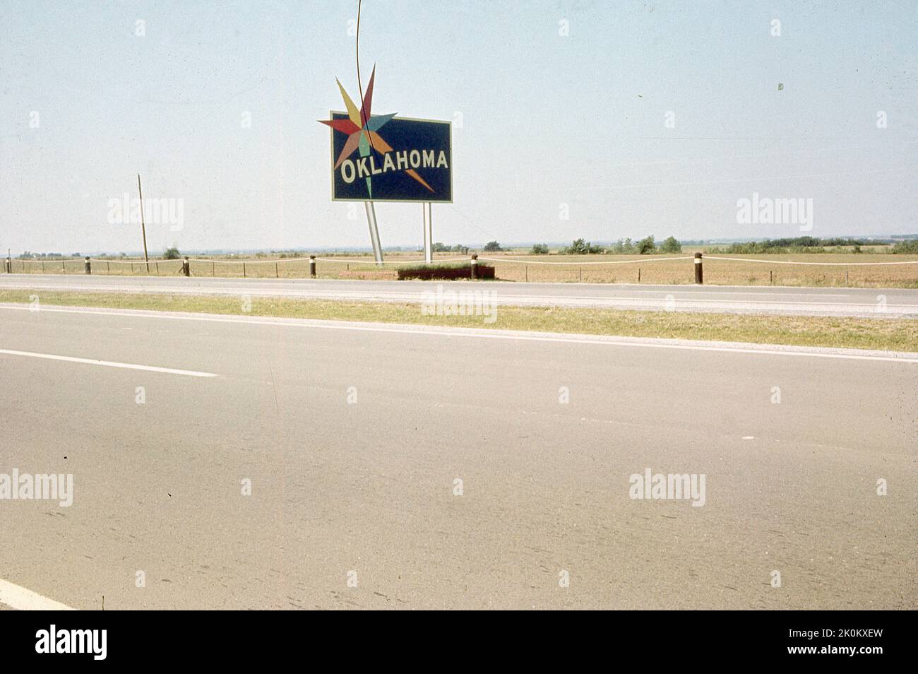 1950s, storica superstrada USA con indicazioni stradali per Oklahoma, nota per la cultura dei cowboy e la storia dei nativi americani. Prima di diventare uno stato nel 1907, gran parte dell'Oklahoma era territorio indiano, da dove deriva il suo soprannome "Terra dell'uomo Rosso". Lo stato è anche chiamato "Sooner State", un nome dato a coloro che si stabilirono nelle Terre non assegnate, in quello che divenne lo Stato dell'Oklahoma, prima della corsa alla Terra del 1889. Foto Stock