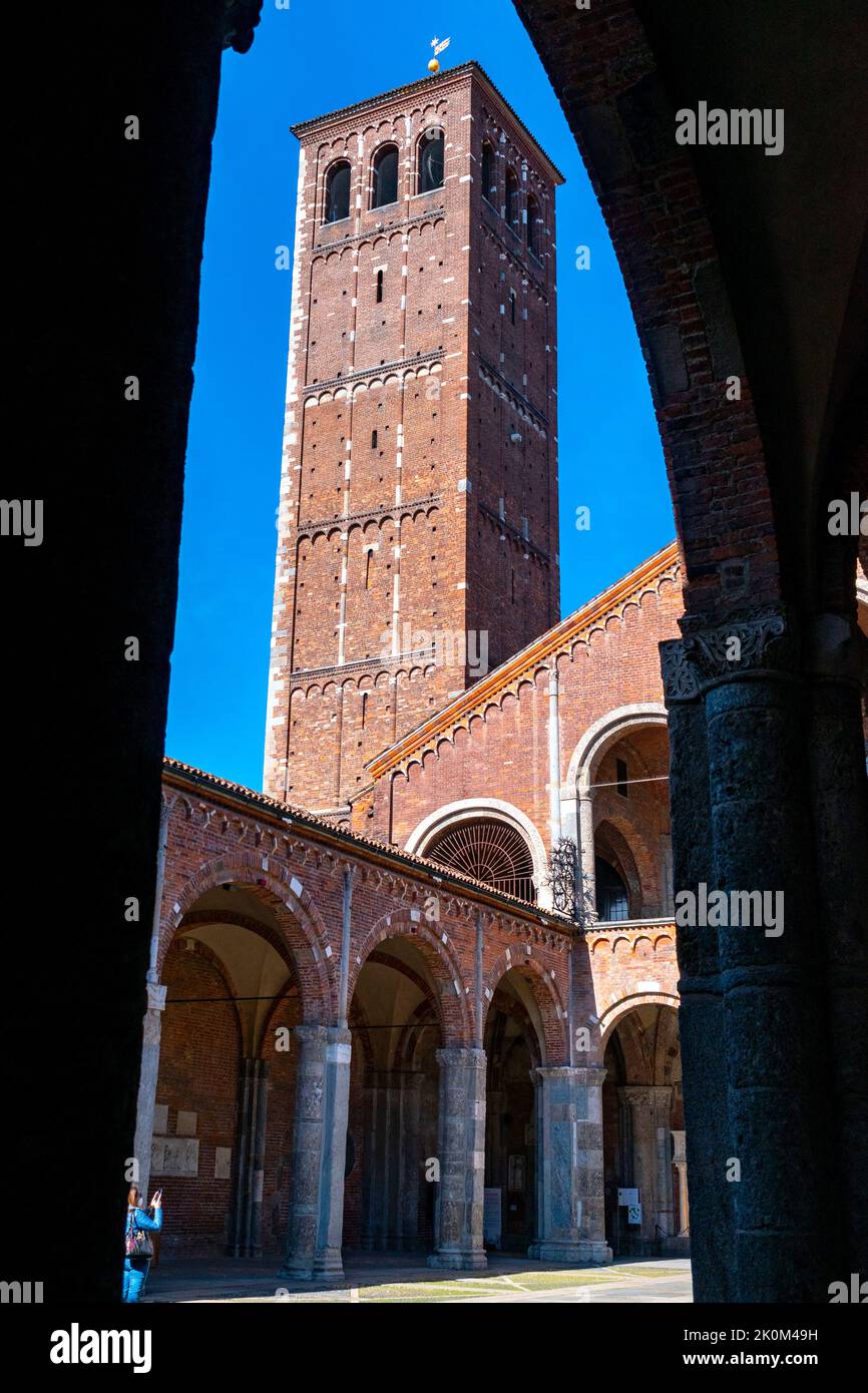 vista della torre canonica attraverso gli archi del cortile della basilica. Basilica romana minore collegiata abbaziale prepositurale di Sant'Ambr Foto Stock