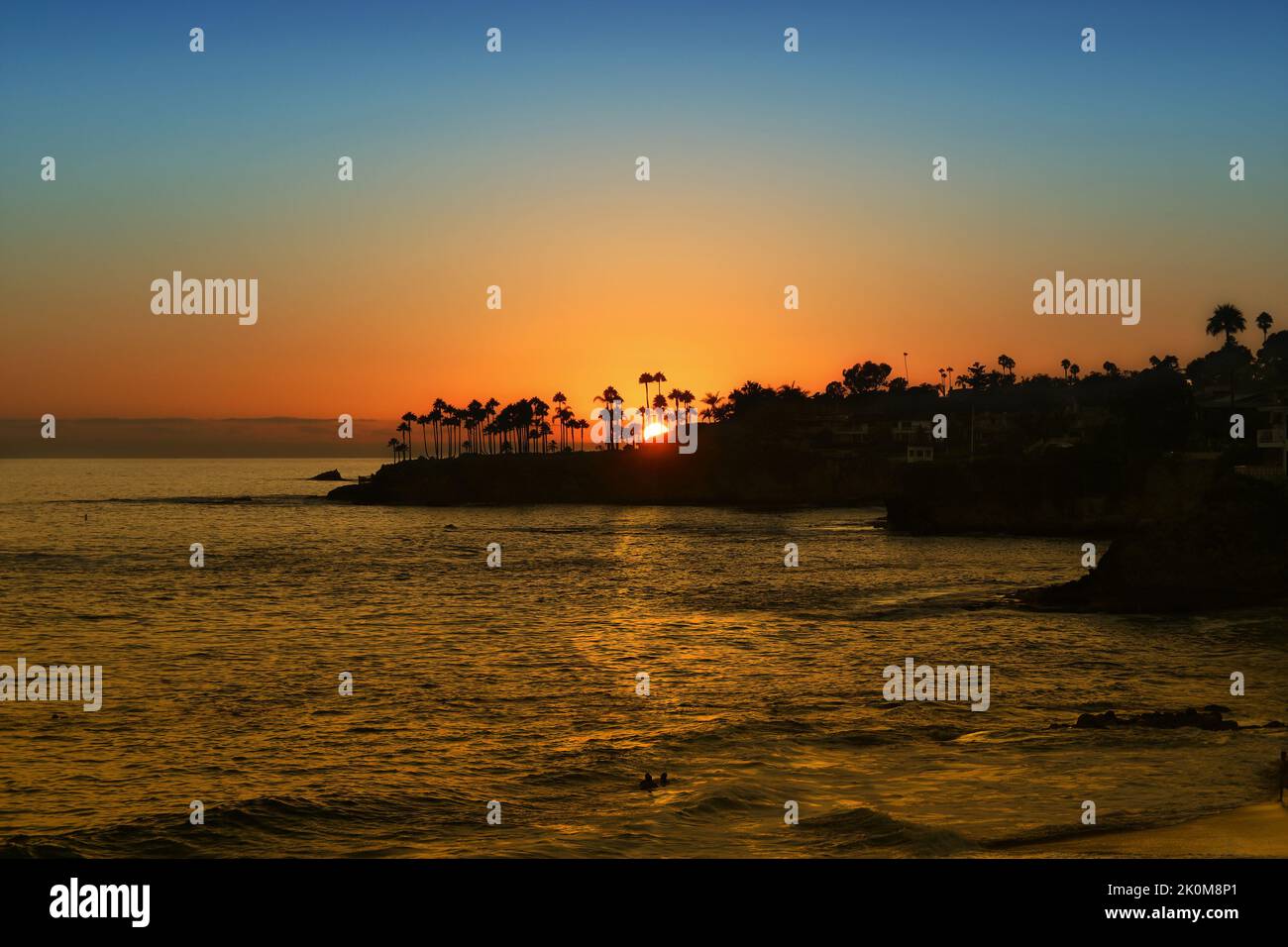 Tramonto dietro Twin Points, Laguna Beach, California, con vista su Fishermans Cove, Shaws Cove e Divers Cove. Foto Stock