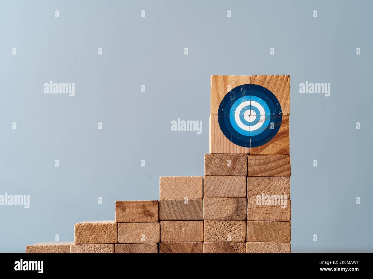 Close up foto della scala fatta di blocchi di legno e il cartello bersaglio sulla cima come simbolo di arrampicata o di lavoro duro per obiettivi e bersagli. Foto Stock