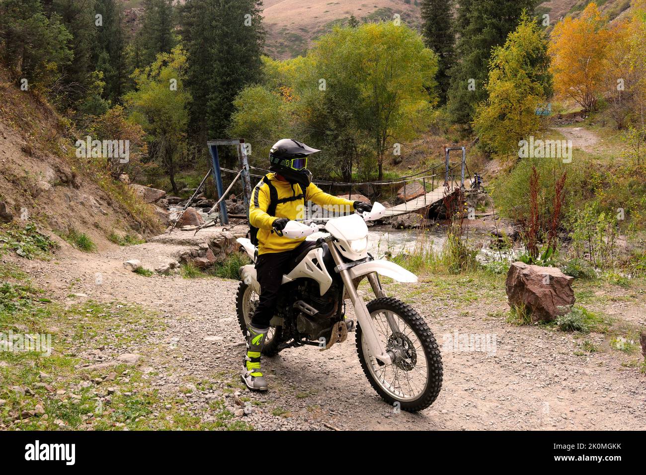 un ragazzo su una moto in montagna in autunno Foto Stock