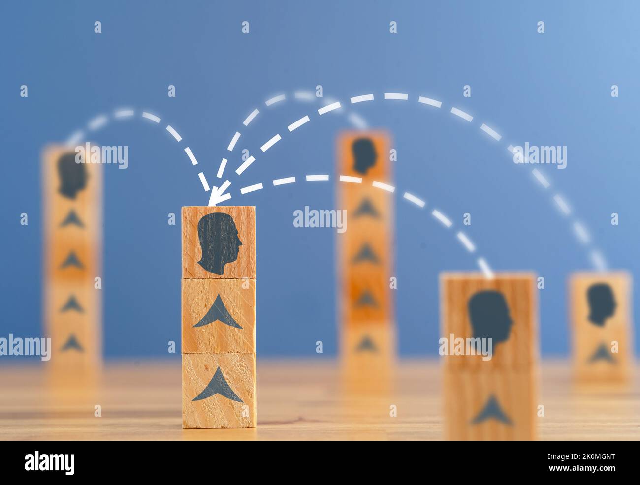 Foto ravvicinata dei blocchi di legno impilati con la silhouette della persona collegata all'altro come simbolo di consenso, lavoro di squadra e networking. Foto Stock