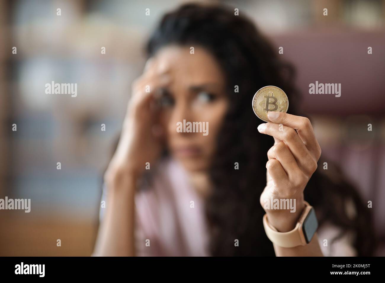 Rovesciato giovane donna in possesso di moneta virtuale bitcoin ufficio Foto Stock