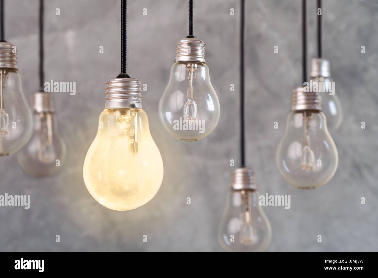 Foto ravvicinata di più lampadine e una di queste è un simbolo di idea, soluzione creativa o innovazione. Foto Stock