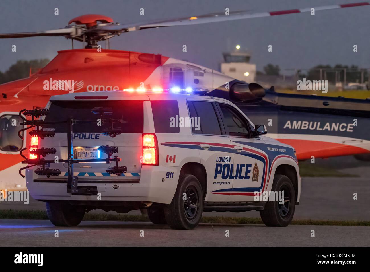 Un'ambulanza aerea di ORNGE sorvegliata da un incrociatore di polizia che si appropria per il decollo per rispondere ad un'emergenza. Foto Stock