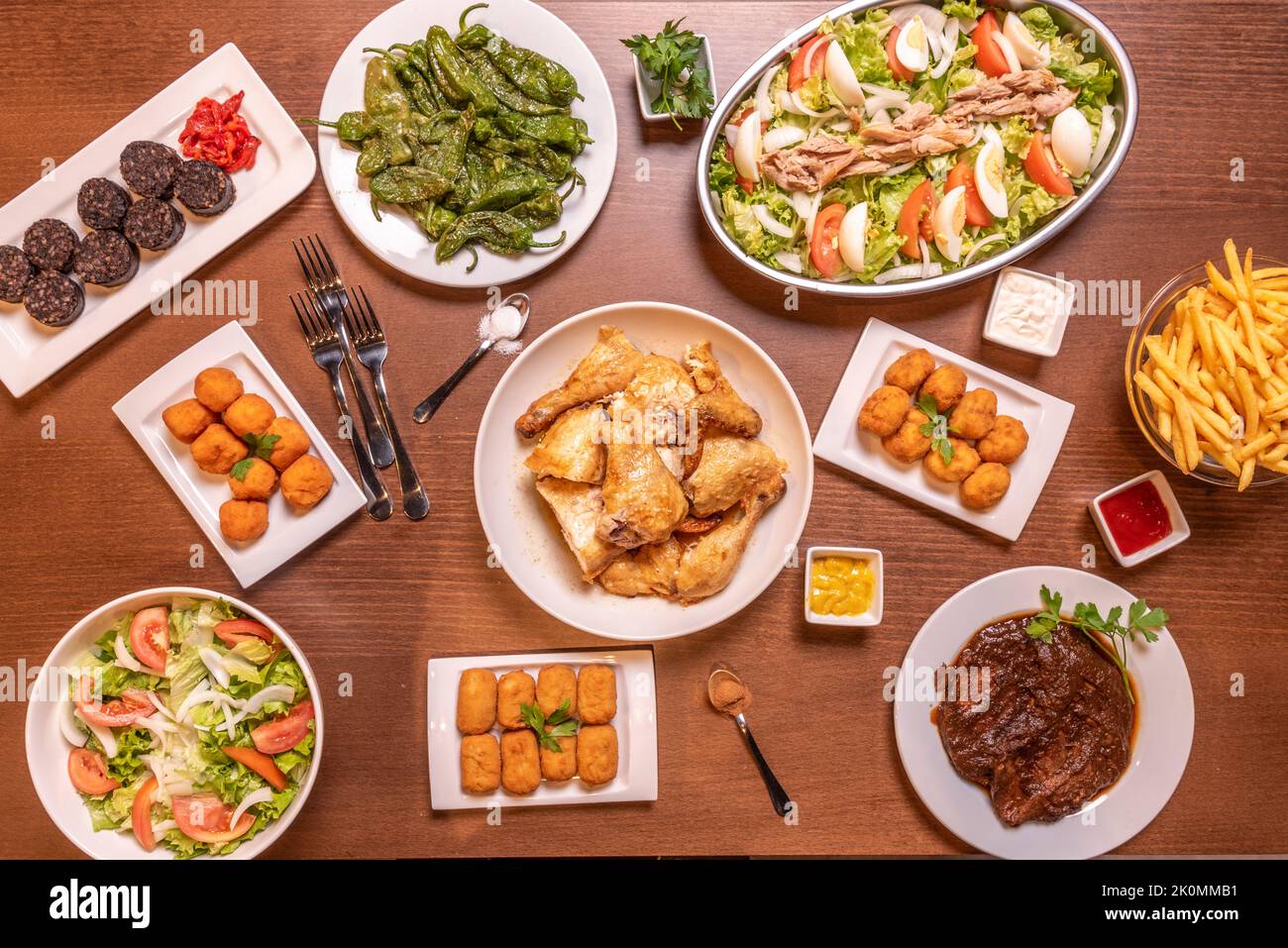 Ricette di piatti tipici spagnoli e tapas con crocchette di vari sapori, insalata con tonno e pomodoro, peperoni fritti, pollo tritato e. Foto Stock