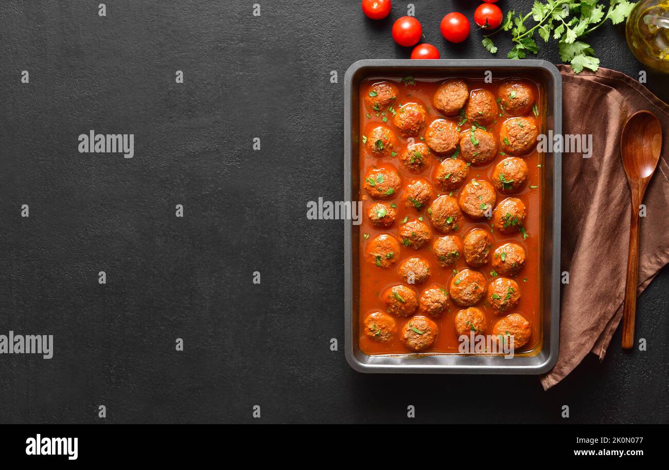 Polpette con salsa di pomodoro in teglia da forno su fondo di pietra scura  con spazio libero per il testo. Vista dall'alto, disposizione piatta Foto  stock - Alamy