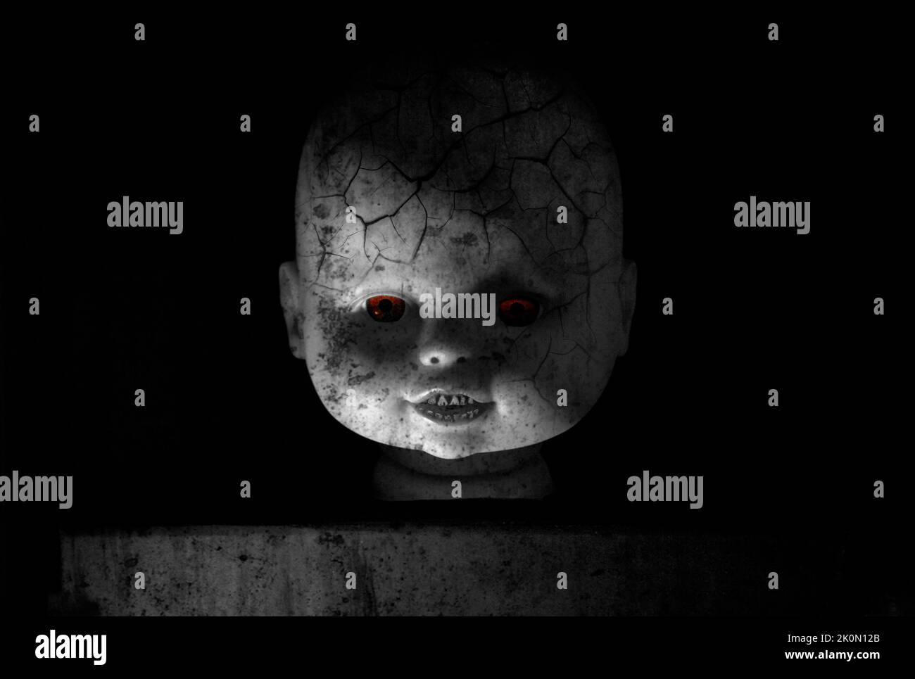 Ritratto di bambola zombie. Sfolgorante volto di bambola con occhi rossi luminosi e pelle zombie su sfondo nero. Concetto di Halloween. Foto Stock