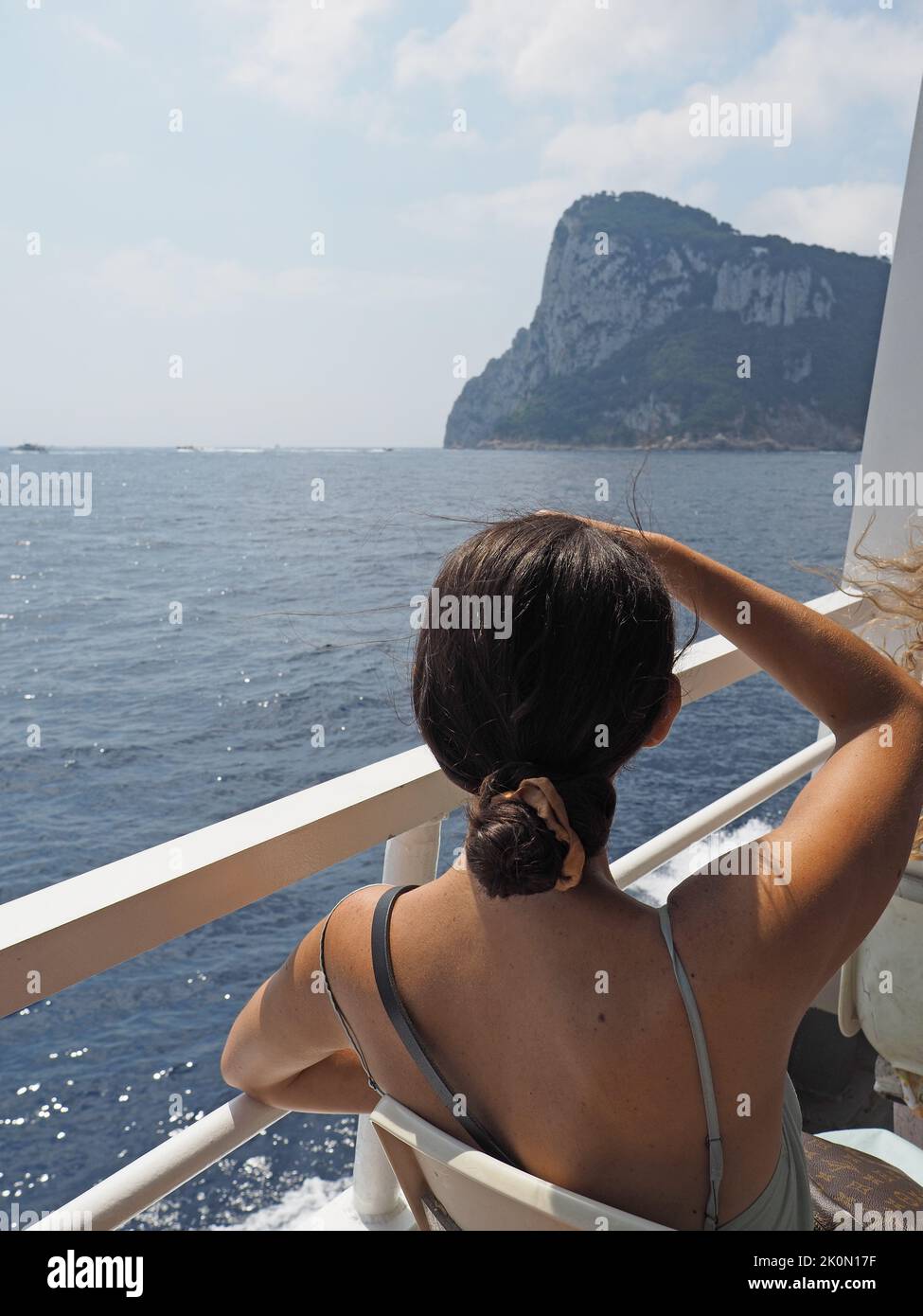 Giovane donna che scherma gli occhi dal sole sul traghetto per Capri, Campania, Italia Foto Stock