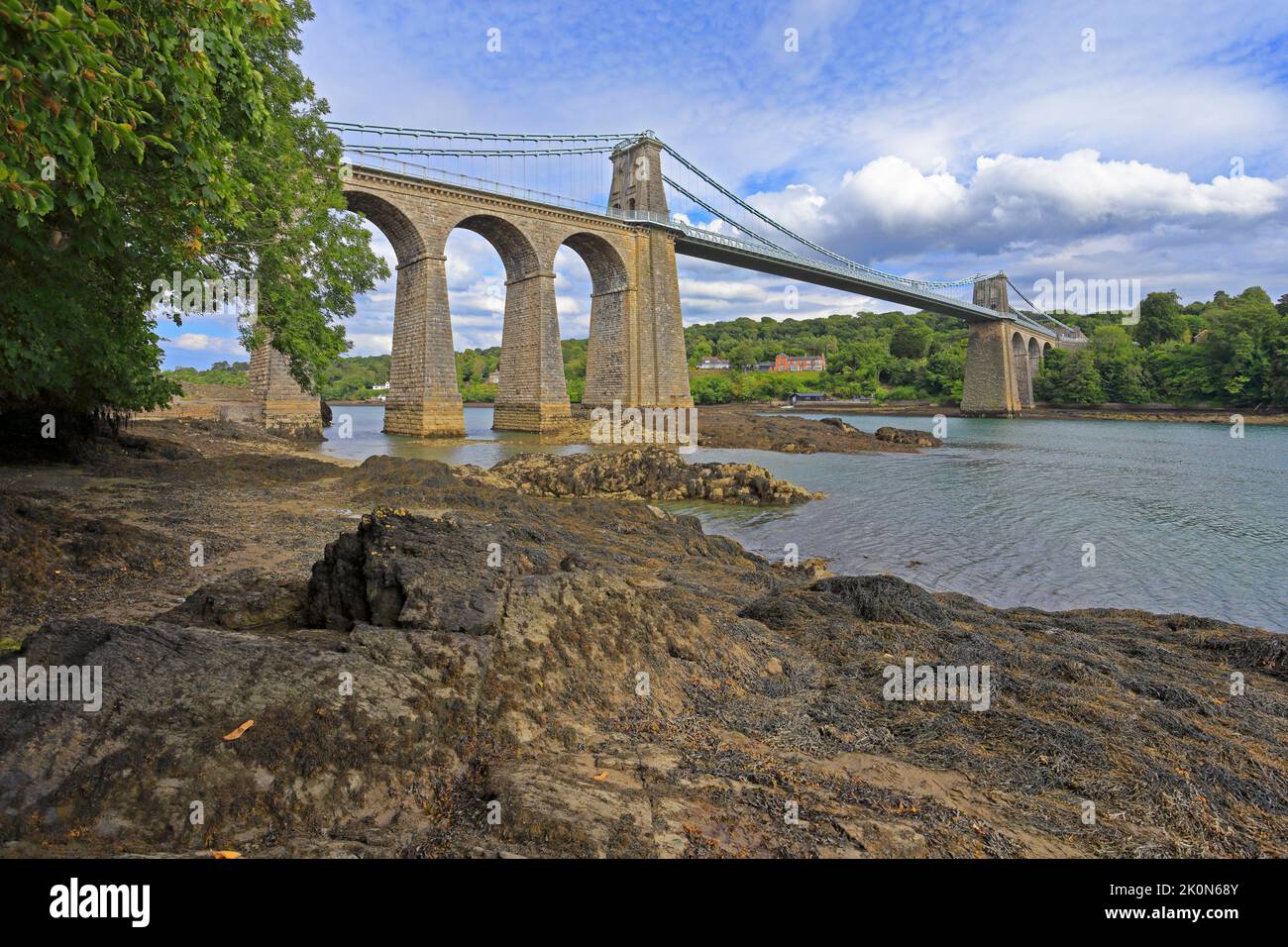 Ponte sospeso Menai di Thomas Telford, Pont Menai, dallo stretto di Menai, dal Ponte Menai, dall'Isola di Anglesey, da Ynys Mon, Galles del Nord, REGNO UNITO. Foto Stock