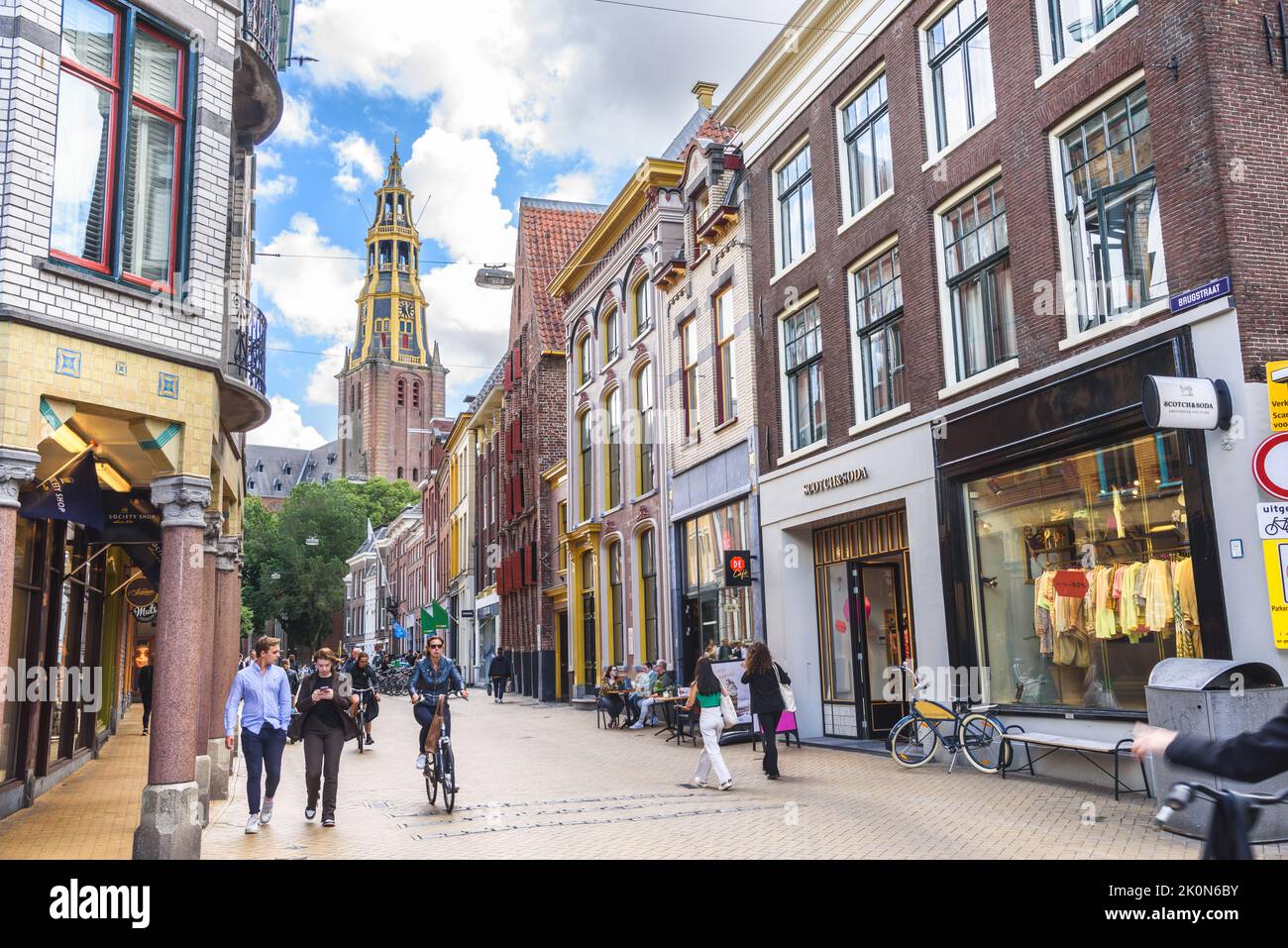 Groningen, Paesi Bassi - 20 giugno 2022: Persone che camminano e pedalano lungo Brugstraat costeggiata da edifici storici nel centro storico della città Foto Stock