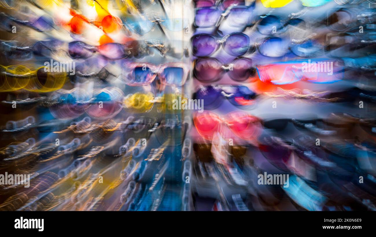 Molti occhiali da sole nel negozio. Zoom. Sfocatura. Fuori fuoco. Sfondo del design. Foto di alta qualità Foto Stock