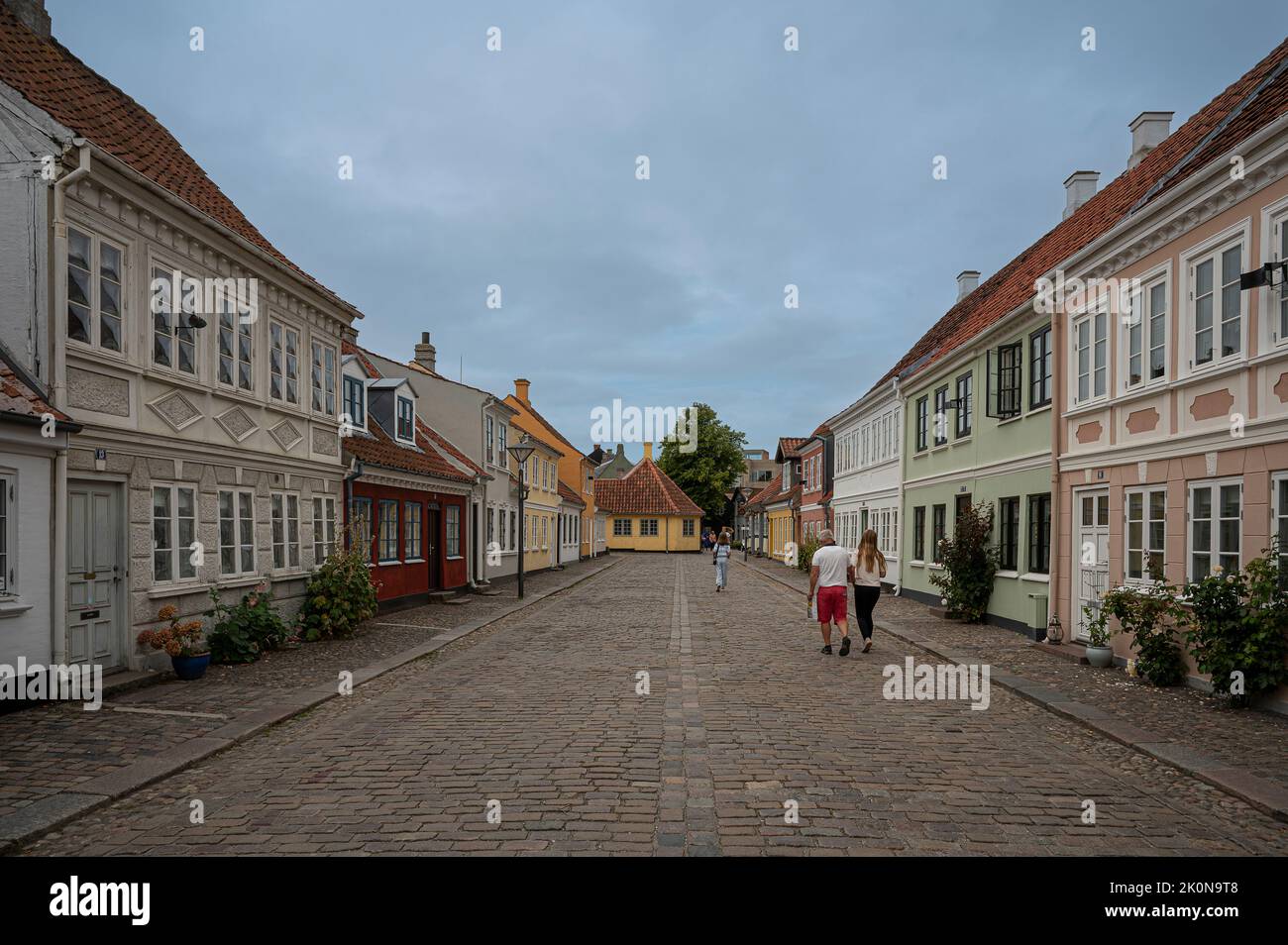Persone che camminano lungo la via Ramsherred fino alla gialla casa di H C Andersen alla fine, Odense, Danimarca, 27 agosto 2022 Foto Stock