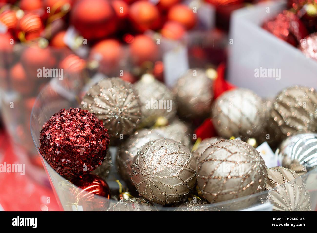 Scintillanti palle dorate e rosse di Natale nel cestino del store.The concetto di vacanze, il divertimento di Capodanno, le vendite e gli acquisti. Sfondo dorato . Spazio di copia. Foto Stock