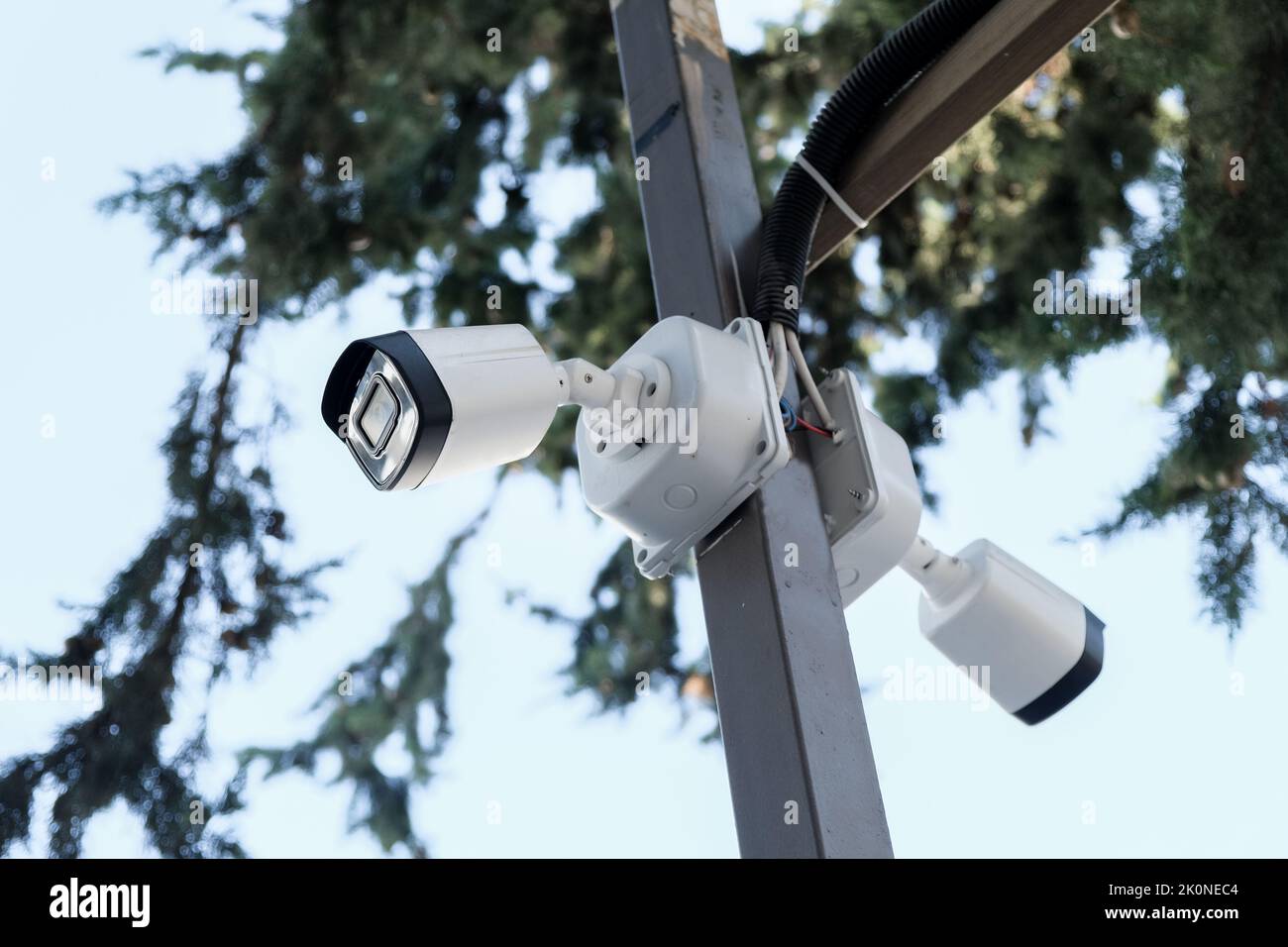telecamera di sicurezza bianca, cielo blu sullo sfondo, tecnologia e sistemi di sicurezza. Foto Stock