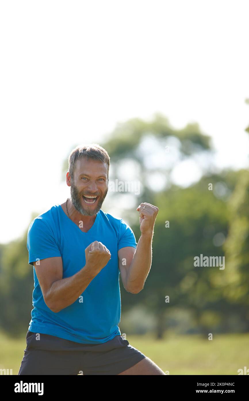 Celebrare la vita. Un uomo maturo che guarda molto eccitato mentre celebra una vittoria fuori. Foto Stock