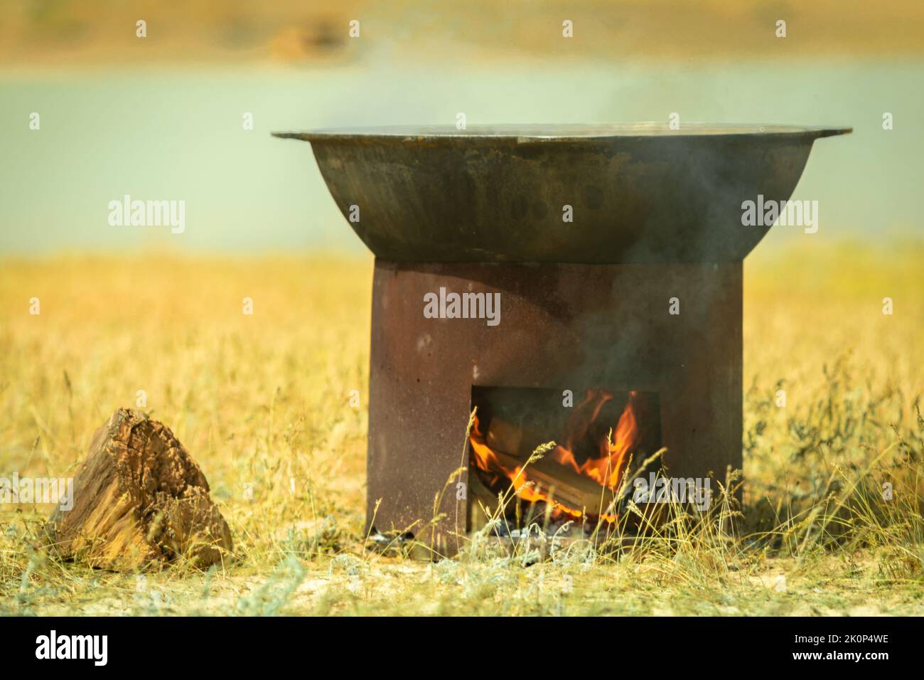 Campo cucina. Un grande calderone è riscaldato su un braciere. Cucinare pilaf nella steppa dell'asia centrale Foto Stock