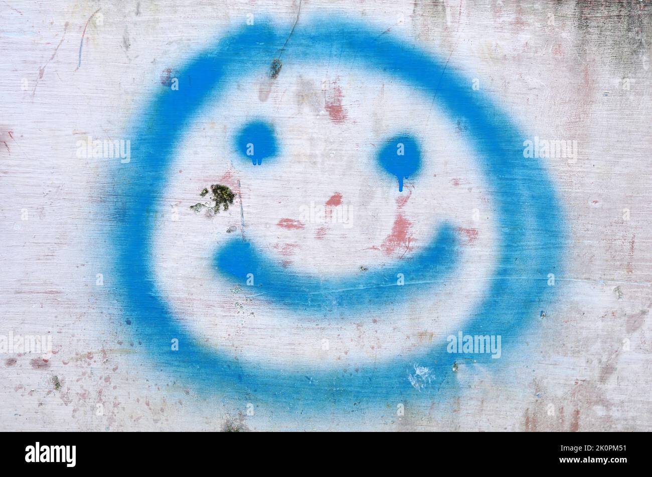 Immagine o illustrazione di un'icona di sorriso blu realizzata con vernice spray sulla parete Foto Stock