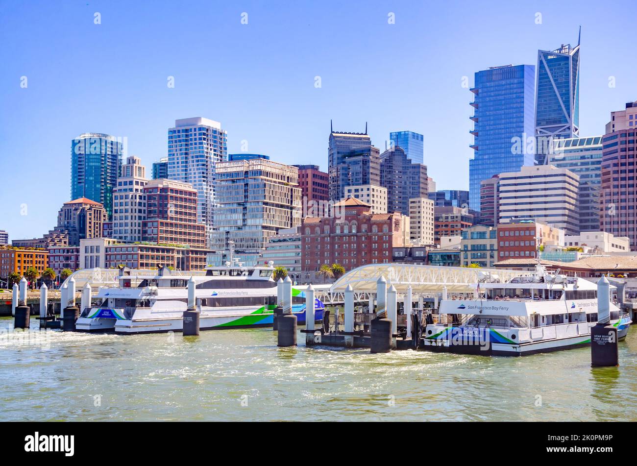 I San Francisco Bay Ferries attraccano nel porto dei traghetti di San Francisco con lo skyline della città. Foto Stock