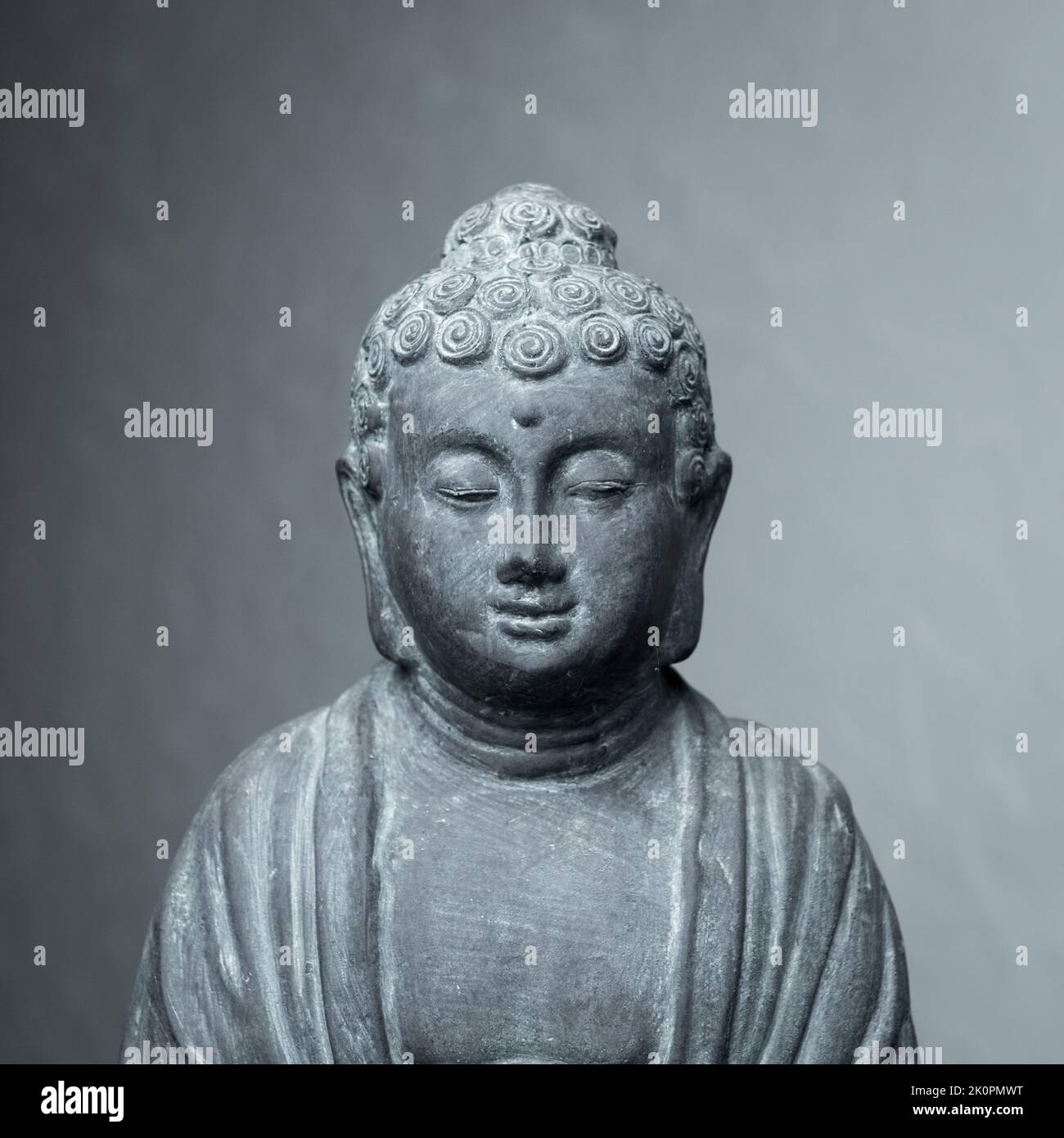Statua di Siddharha Gautama Buddha fatta di pietra grigia come decorazione interna Foto Stock