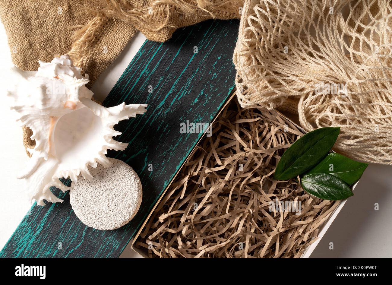 Mock up per i vostri cosmetici o prodotto con conchiglie, su uno sfondo di legno con materiali naturali eco-friendly.Flat Lay.The concetto di stile di vita ecologico, scatola per il vostro prodotto e zero rifiuti. Foto Stock