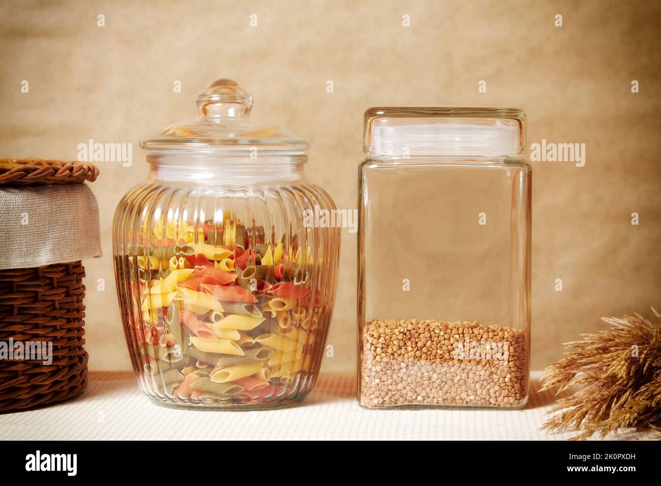 Grano saraceno e pasta colorata su un tavolo da cucina accogliente. Utensili da cucina e cucina Foto Stock
