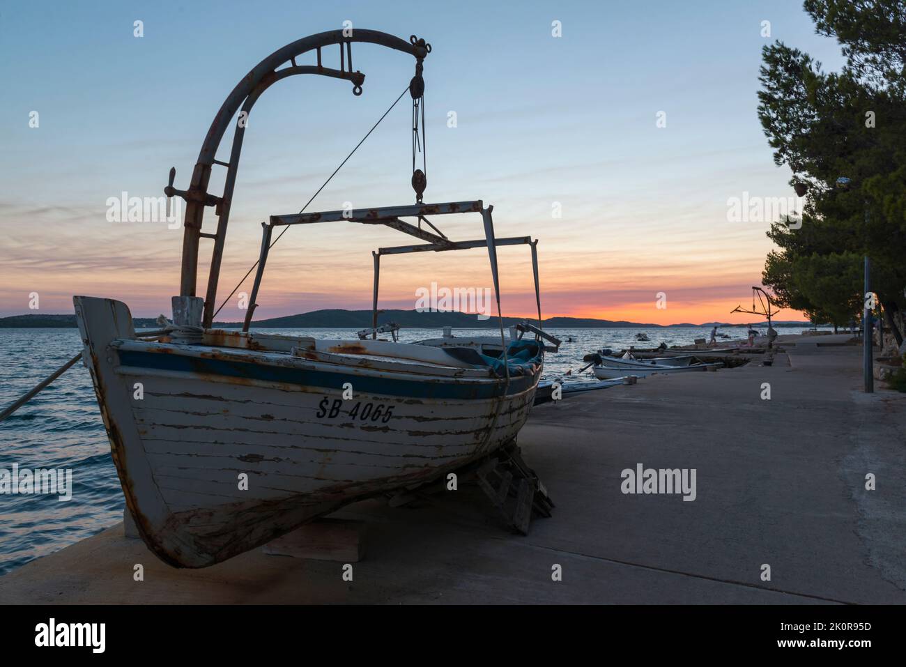 Una barca di legno issata sulla banchina di Broderica al tramonto. Croazia, Europa Foto Stock