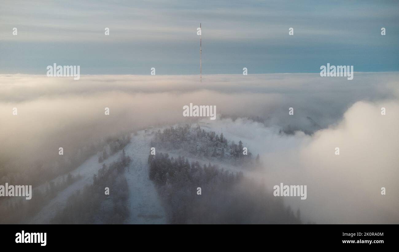 Alba che si infrana attraverso la fitta nebbia bianca sulla cima della collina Vuokatti, una stazione sciistica a Vuokatti, Finlandia. L'esperienza scandinava dell'inverno. MO Foto Stock