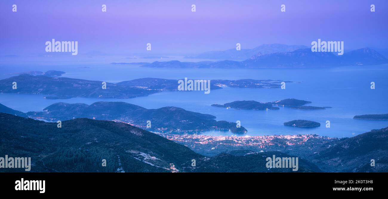 Montagne, isole e città sul mare costa di notte Foto Stock
