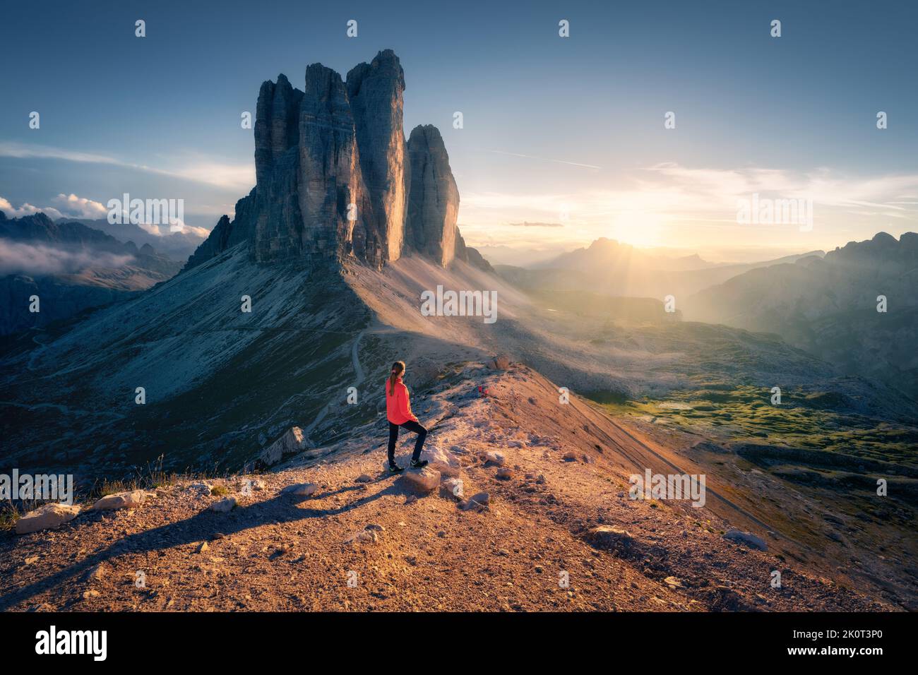 Ragazza sulla cima della montagna e incredibili rocce alte al tramonto Foto Stock